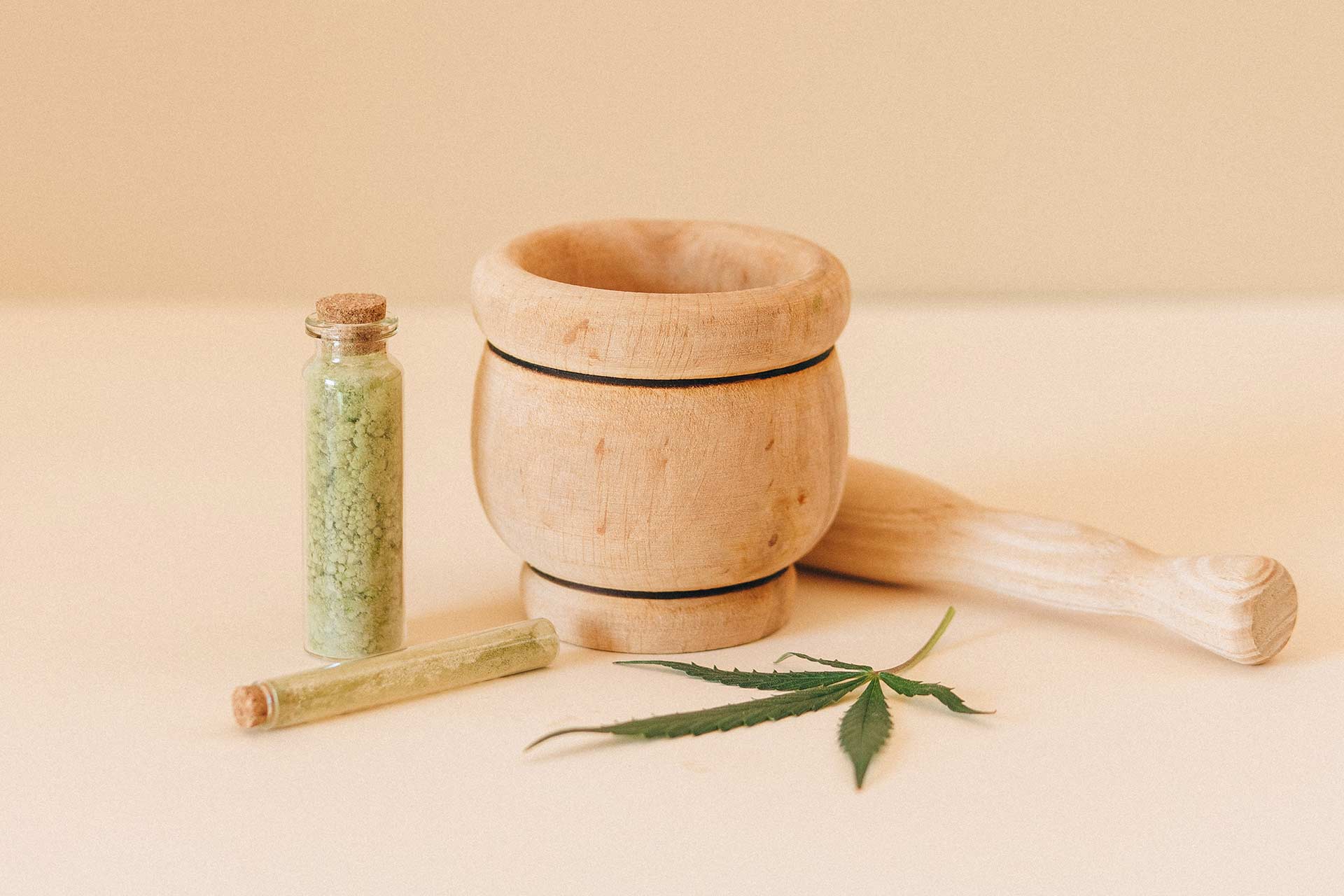 cannabis next to a wooden mortar and pestle
