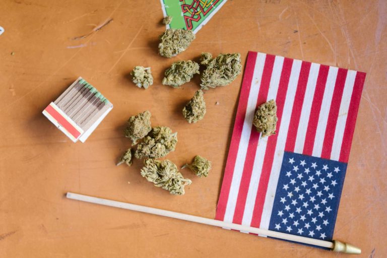 US flag on table with cannabis flower and matches