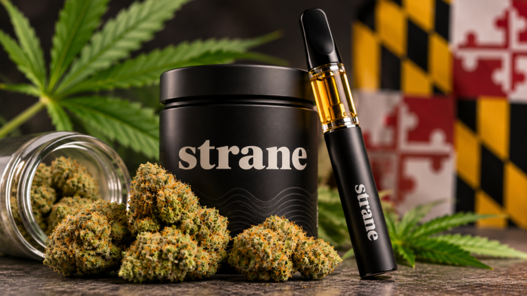 Close-up of premium cannabis flower buds, an unbranded black cannabis container, and a vape cartridge with amber oil against a blurred Maryland-inspired background, illustrating a review of cannabis flower and vape products.